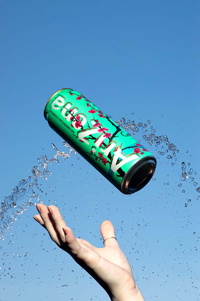 A Can of Arizona flying above a hand